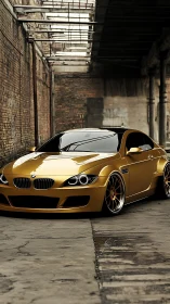 Gold widebody BMW coupe in derelict industrial alleyway.