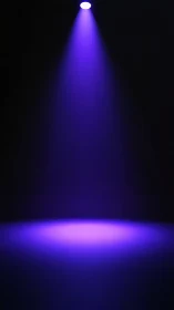 Purple stage spotlight beam on empty dark background.