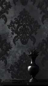 Black vase against dark damask wall in moody lighting.