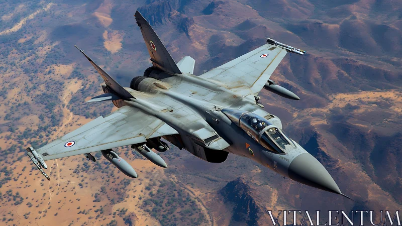 Modern twin‑engine fighter jet in flight over arid terrain.