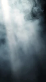 Light shaft penetrating dense white smoke in darkness.