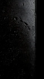 Textured dark surface with subtle side lighting detail.