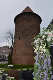 The Gdańsk Powder Tower Casts A Dark Shadow Over Vibrant Flowers