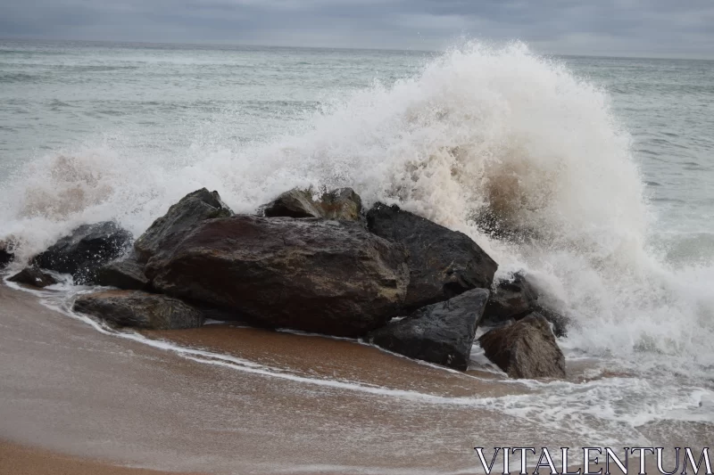 Powerful Wave Breaking Over Rocks at the Beach Free Stock Photo