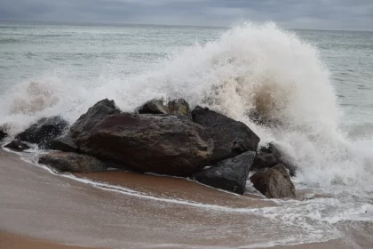 Powerful Wave Breaking Over Rocks at the Beach