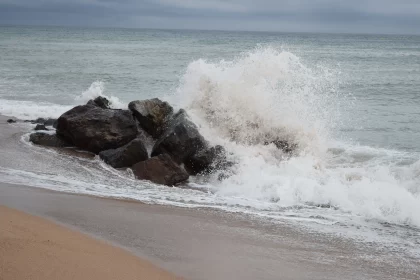 Stormy Coastal Scene with Surfer and Rocky Beach