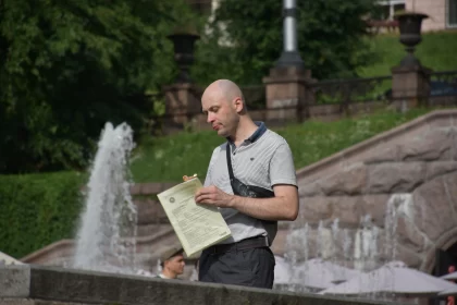 Ukrainian Man Reading by City Fountain