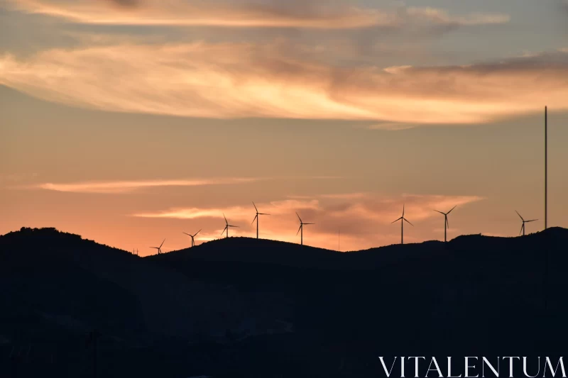 Sunset Wind Turbines on Hilltop with Mountainous Backdrop Free Stock Photo