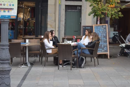 Outdoor Cafe Scene with Women in Wicker Chairs