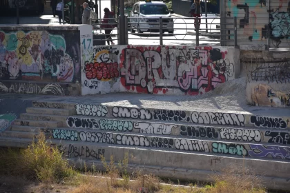 Skateboarders in Graffiti-Adorned Urban Landscape Free Stock Photo