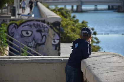 Playful Boy Overlooking Water - Street Art Inspired Free Stock Photo