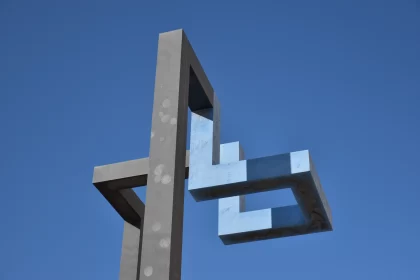 Metal Sculpture with Biblical Iconography Against Blue Sky