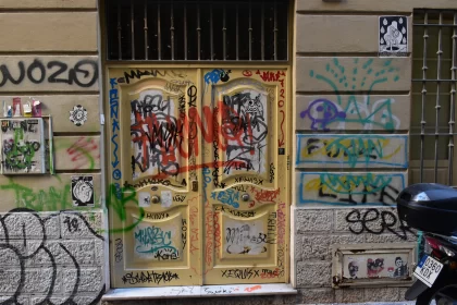 Graffiti Art on Yellow Door - A Tale of Urban Rebellion Free Stock Photo