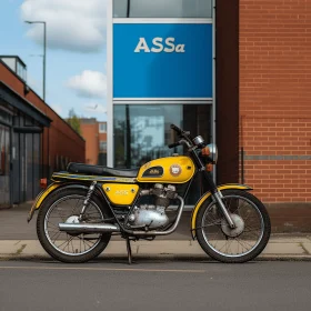 Yellow Motorcycle Parked in Front of Brick Building | Commercial Imagery