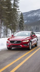 Red Volvo S60 Car Driving on Snowy Road with Forest and Mountains