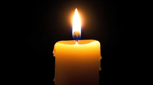 Illuminated Candle with Flame in Darkness