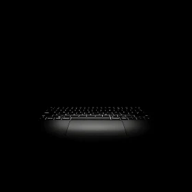 Backlit Laptop Keyboard Shining in Darkness