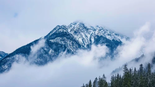 Majestic Snow-Capped Mountain Surrounded by Swirling Clouds