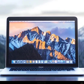 Laptop Displaying Snow-Capped Mountains at Sunset