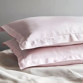 Stacked Pink Pillows on White Sheet