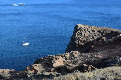 Sailboat by Rocky Cliff