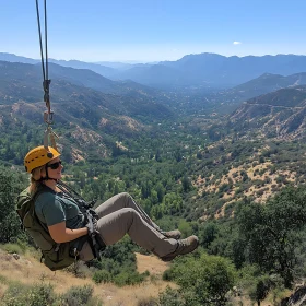 Woman Ziplining Through Mountain Landscape