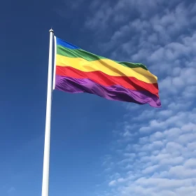 Pride Flag Against a Cloudy Blue Sky