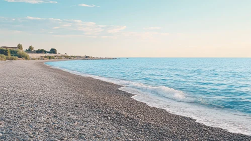 Calm Pebble Shoreline with Gentle Waves and Blue Horizon