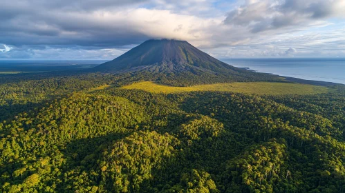 Mountain with Clouds Above Lush Forest and Sea