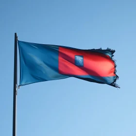 Flag with Frayed Edges Fluttering Against Clear Sky