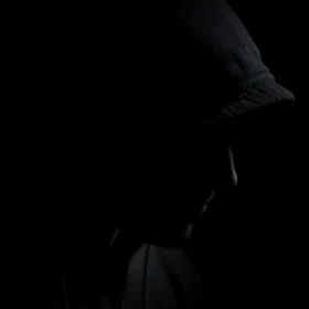 Enigmatic Hooded Silhouette in Darkness