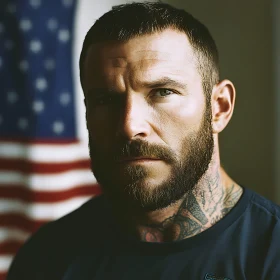 Serious Man with Beard and Tattoos in Front of Flag