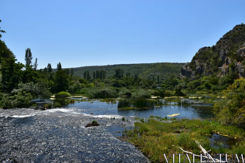 Serene Nature Scene with River and Green Hills Free Stock Photo