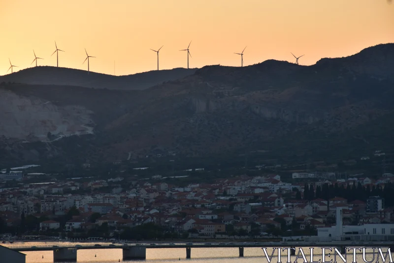 PHOTO Windmills and City at Sunset