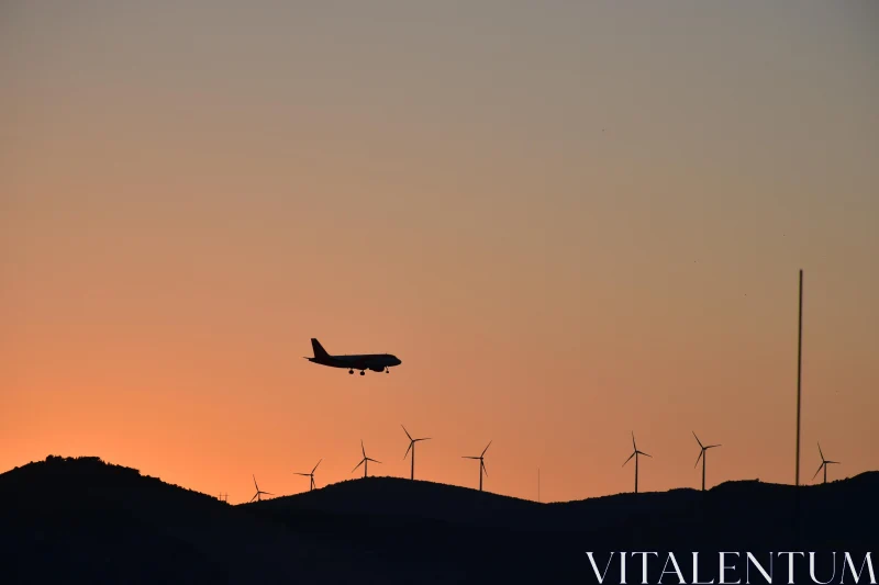 PHOTO Airplane and Wind Turbines at Sunset