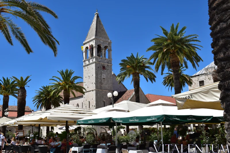 Trogir's Iconic Bell Tower and Lively Cafe Scene Free Stock Photo