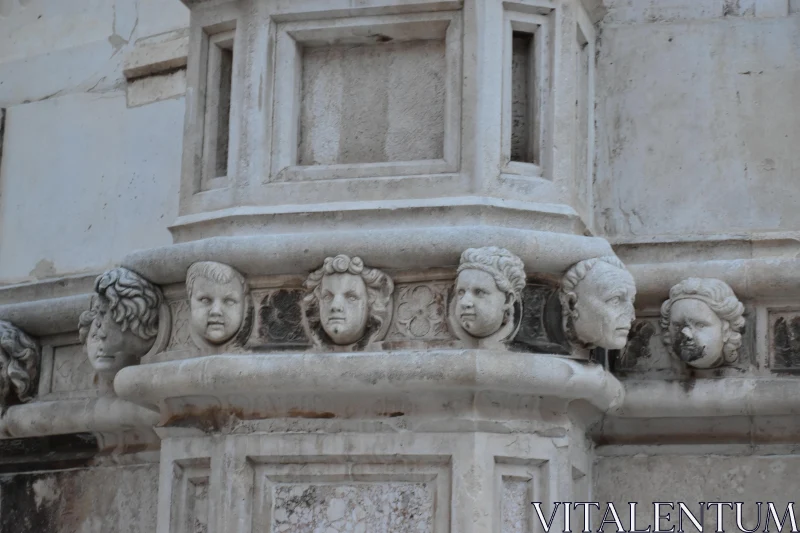 Classical Stonework with Sculpted Faces Free Stock Photo