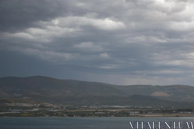 Town at Mountain Base Under Clouded Sky Free Stock Photo