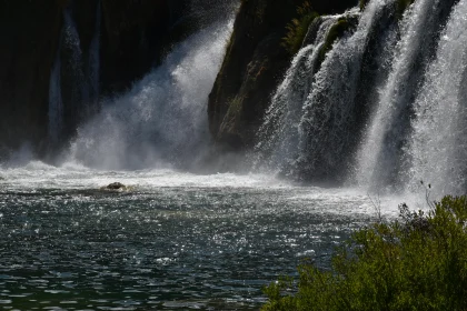 Serene Waterfall and River with Sunlit Mist