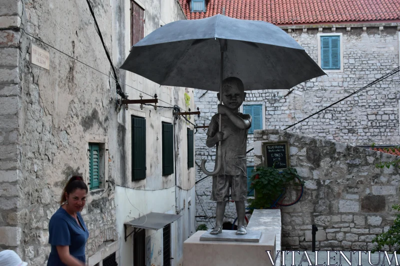 Child Holding Umbrella Statue in Alley Free Stock Photo