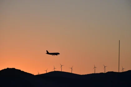 Airplane and Wind Turbines at Sunset