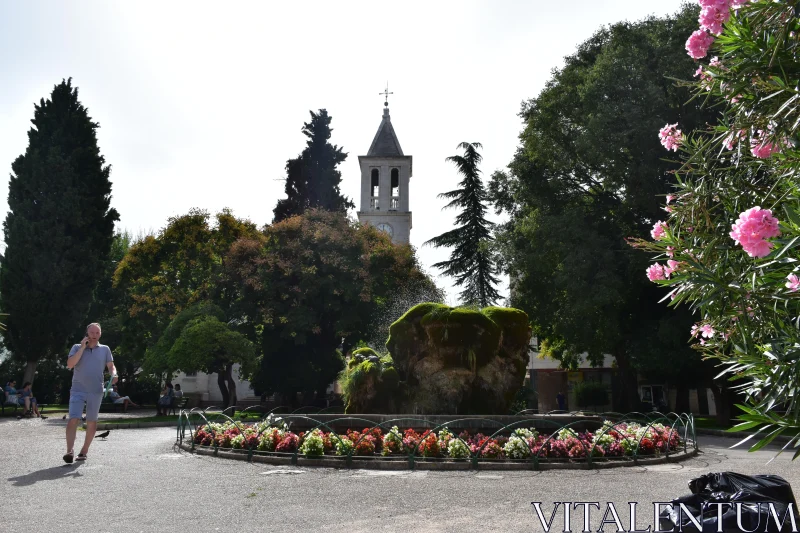 PHOTO Picturesque Urban Garden with Stone Tower